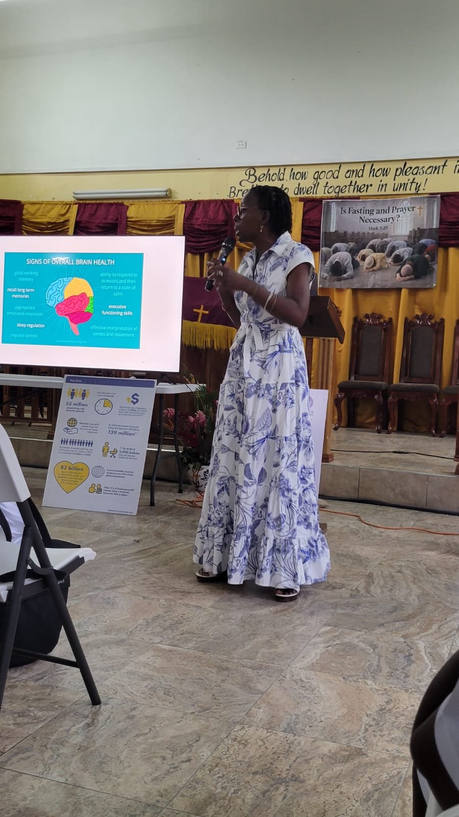An older woman speaking to a small community group
